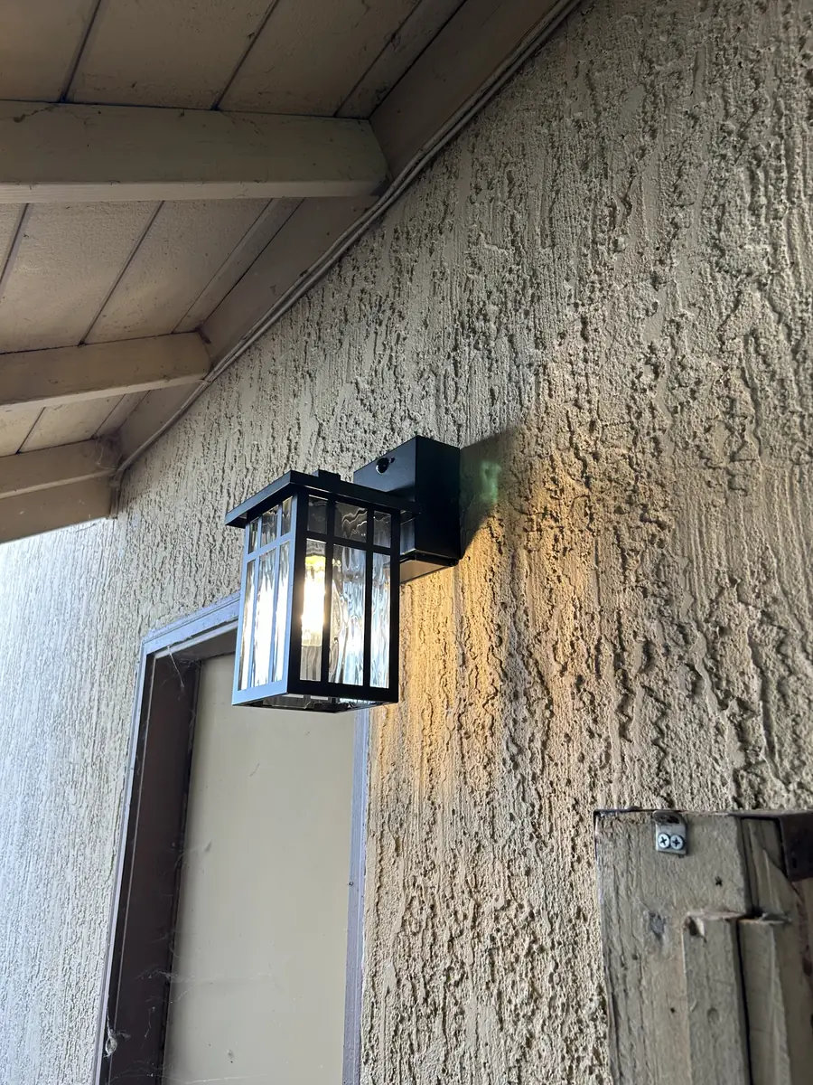 Wall lantern beside a front door under a covered porch